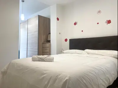a white bedroom with a large bed with white sheets at Apartment Marina in Vilanova i la Geltrú