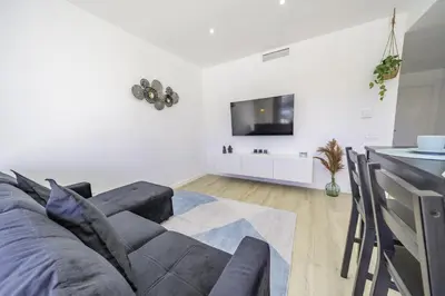 a living room with a couch and a tv on a wall at HomeHolidaysRentals Kala - Costa Barcelona in Pineda de Mar
