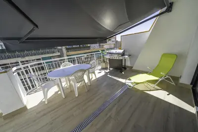 a room with a table and chairs on a balcony at HomeHolidaysRentals Kala - Costa Barcelona in Pineda de Mar