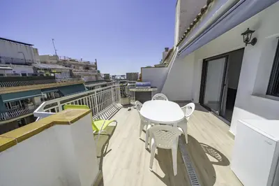a balcony with a table and chairs on a building at HomeHolidaysRentals Kala - Costa Barcelona in Pineda de Mar