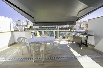 a table and chairs on a balcony with a grill at HomeHolidaysRentals Kala - Costa Barcelona in Pineda de Mar