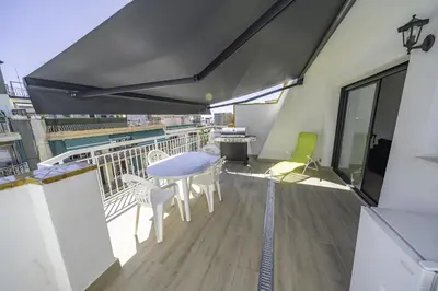 a balcony with a table and chairs on a building at HomeHolidaysRentals Kala - Costa Barcelona in Pineda de Mar