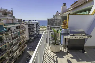 a balcony with a grill and some buildings at HomeHolidaysRentals Kala - Costa Barcelona in Pineda de Mar