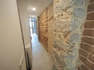a hallway with a stone wall in a room at Antic Manresa Atico in Manresa