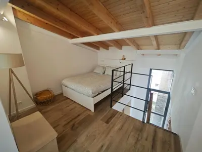 a small bedroom with a bed and a glass staircase at Antic Manresa Atico in Manresa