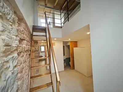 a staircase in a room with a stone wall at Antic Manresa Atico in Manresa