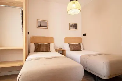 two beds sitting in a room with a window at Stay U-nique Apartment Comte Güell in Barcelona