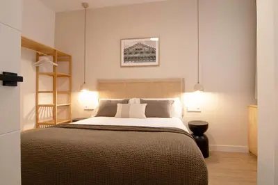 a bedroom with a large bed and two lights at Stay U-nique Apartment Comte Güell in Barcelona