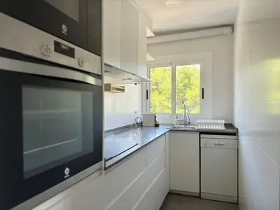 a large white kitchen with a stove top oven at Golden hours by the sea in Castelldefels