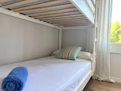 a bed with a blue towel on it in a bedroom at Golden hours by the sea in Castelldefels