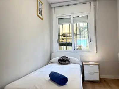 a bedroom with a cat sitting on a bed at Golden hours by the sea in Castelldefels