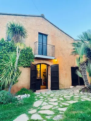 a building with palm trees in front of it at Cal Mingo in Viladellops