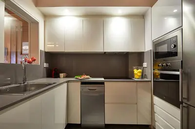 a kitchen with white cabinets and a sink at BBarcelona Urban Apartments in Barcelona
