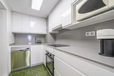 a kitchen with white cabinets and a microwave at HomeholidayRentals Singular - Costa Barcelona in Pineda de Mar