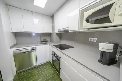 a kitchen with white cabinets and a microwave at HomeholidayRentals Singular - Costa Barcelona in Pineda de Mar