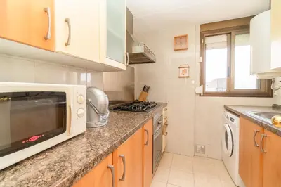 a kitchen with a microwave and a stove at Apartamento Acqua Fresca in Cunit