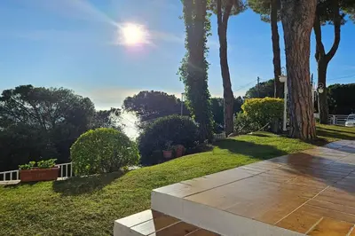 a walkway in a park with a waterfall in the background at Casa perfecta con vistas al Mar in San Pol de Mar