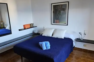 a bedroom with a bed with a blue blanket at Casa perfecta con vistas al Mar in San Pol de Mar