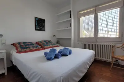 a bedroom with a large white bed with blue pillows at Casa perfecta con vistas al Mar in San Pol de Mar
