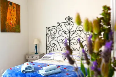a bedroom with a bed with a blue comforter at La Llar de la Kim, ideal familias in Arenys de Mar