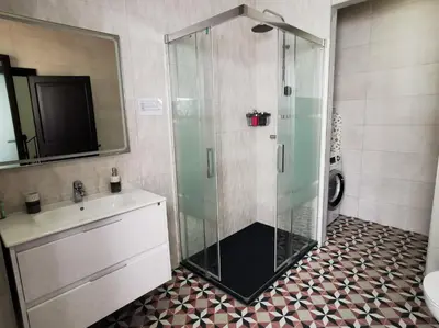 a bathroom with a glass shower and a sink at La Llar de la Kim, ideal familias in Arenys de Mar