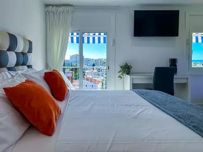 a bedroom with a large white bed and a window at Urban Waves by Hello Homes Sitges in Sitges
