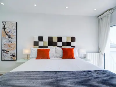 a bedroom with a large bed with orange and white pillows at Urban Waves by Hello Homes Sitges in Sitges