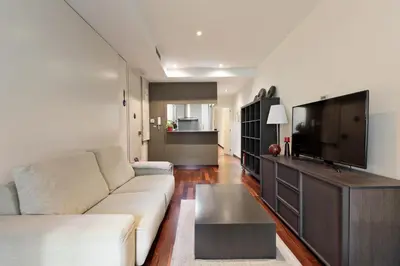 a living room with a couch and a flat screen tv at Frida by EnjoyApartments in Barcelona
