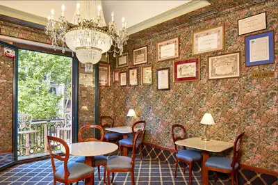 a restaurant with tables and chairs and a chandelier at Hotel Continental Barcelona in Barcelona