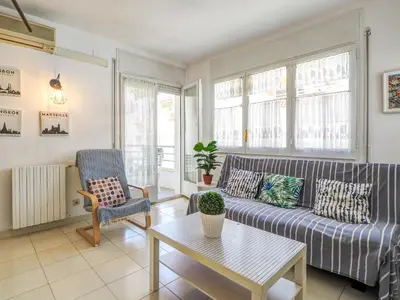 a living room with a couch and a table at Llopart Apartment by Hello Homes Sitges in Sitges