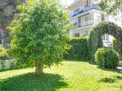 a tree in a yard in front of a building at Llopart Apartment by Hello Homes Sitges in Sitges