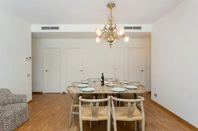 a dining room with a table with chairs and a chandelier at Canela Homes BARCELONA ICÀRIA in Barcelona
