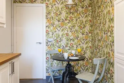 a table in a kitchen with two chairs and a wallpaper at Canela Homes BARCELONA ICÀRIA in Barcelona