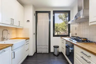 a kitchen with white cabinets and a sink and a window at Canela Homes BARCELONA ICÀRIA in Barcelona