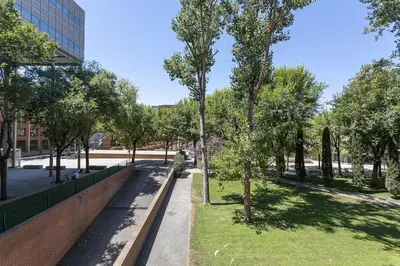 a park with a bench and trees and a building at Canela Homes BARCELONA ICÀRIA in Barcelona