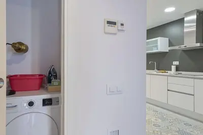 a white kitchen with a washing machine in it at Canela Homes BARCELONA STYLE in Barcelona