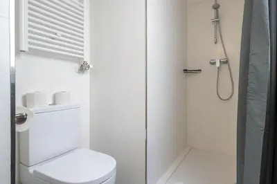 a white bathroom with a toilet and a shower at Canela Homes BARCELONA STYLE in Barcelona