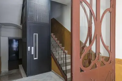a hallway with a staircase with a black door and a stair railing at Canela Homes BARCELONA STYLE in Barcelona