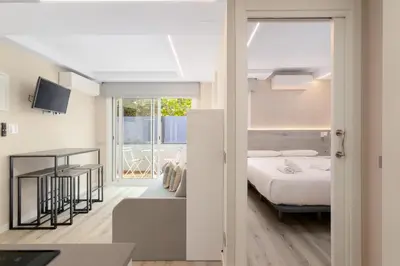 a bedroom with a bed and a balcony at Aparthotel Vilassar in Vilassar de Mar