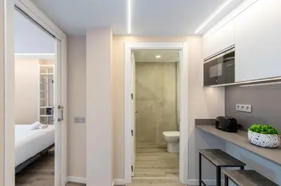 a bathroom with a bed and a toilet in a room at Aparthotel Vilassar in Vilassar de Mar