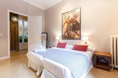 a bedroom with a large bed with a painting on the wall at AinB B&B Born-Via Laietana in Barcelona