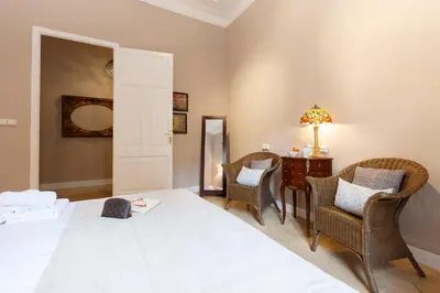 a bedroom with a bed and chairs and a table at AinB B&B Born-Via Laietana in Barcelona