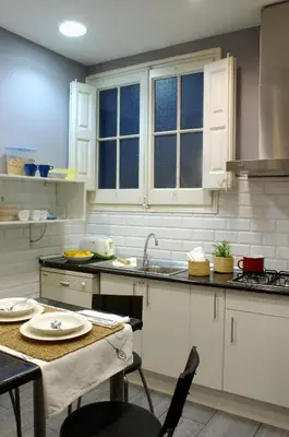 a kitchen with a sink and a table with chairs at AinB B&B Born-Via Laietana in Barcelona