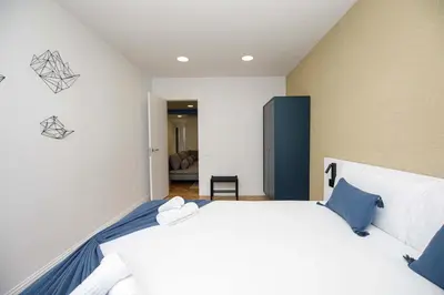 a bedroom with a large white bed with blue pillows at Stay U-nique Apartments Rambla Catalunya VI in Barcelona