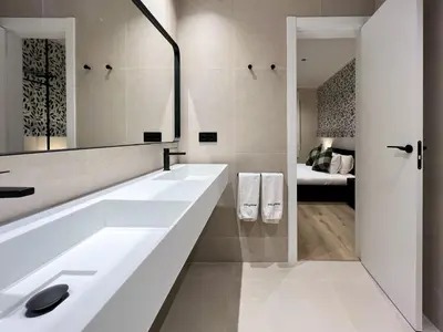 a bathroom with a large white sink and a bedroom at Stay U-nique Apartment Muntaner in Barcelona