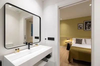 a bathroom with a white sink and a mirror at Stay U-nique Apartment Muntaner in Barcelona