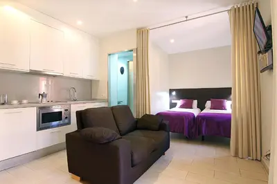 a kitchen and a living room with a couch and a bed at ClassBedroom Barcelona Beach Apartments in Barcelona