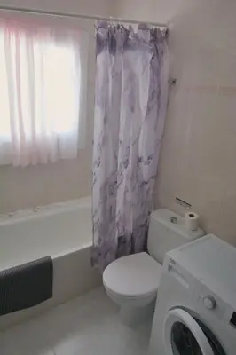 a bathroom with a toilet and a shower curtain at Apartamento Sunny Home in Cunit