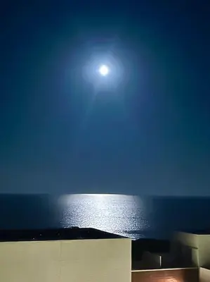 a view of the ocean at night with the moon at Sitges espectacular vista al mar in Sant Pere de Ribes