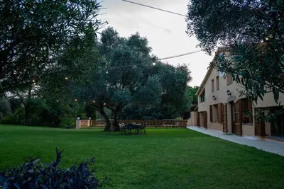 a yard with a building and a tree and a table at Casa rural El Bruguer Vell in Santa Eulalia de Ronsaná